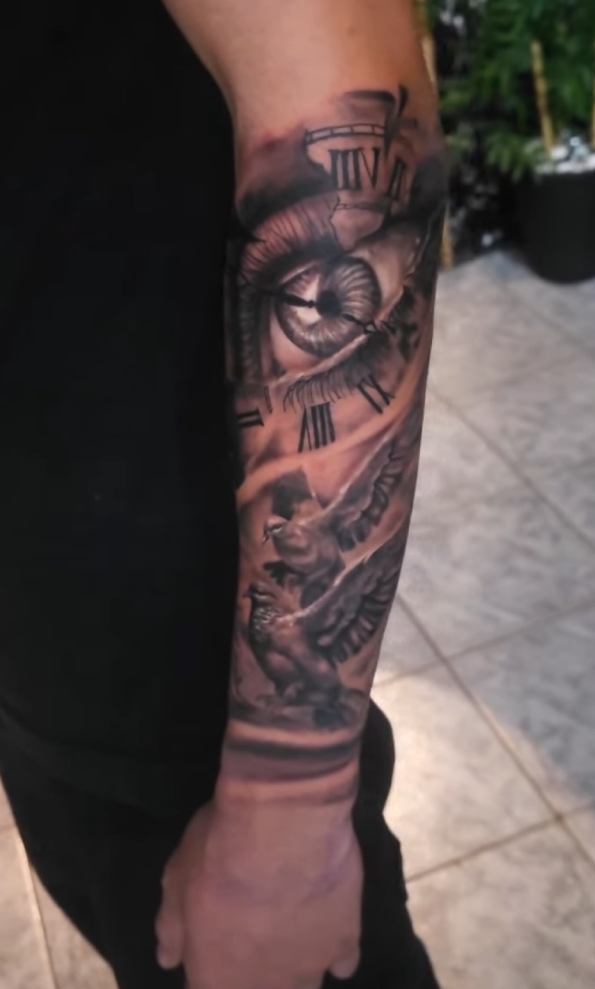 Black and grey clock and statue sleeve tattoo