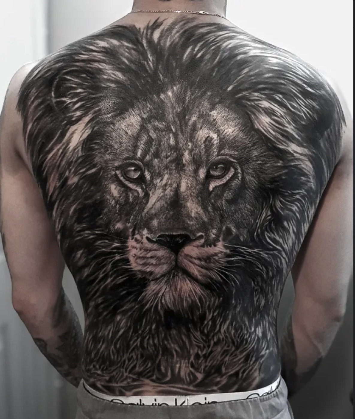Black and grey lion back piece tattoo