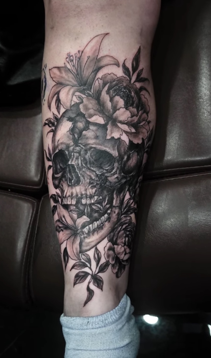 Black and grey skull and lilies tattoo