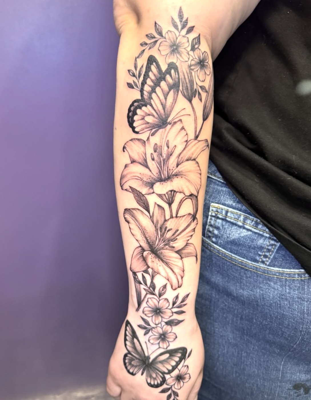 Black and grey butterfly and lilies floral sleeve tattoo